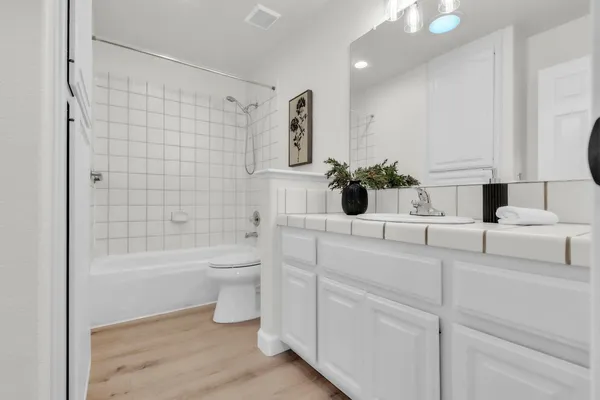 a bathroom with a double vanity sink toilet and shower
