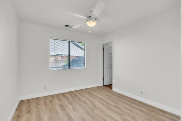 an empty room with a window and wooden floor