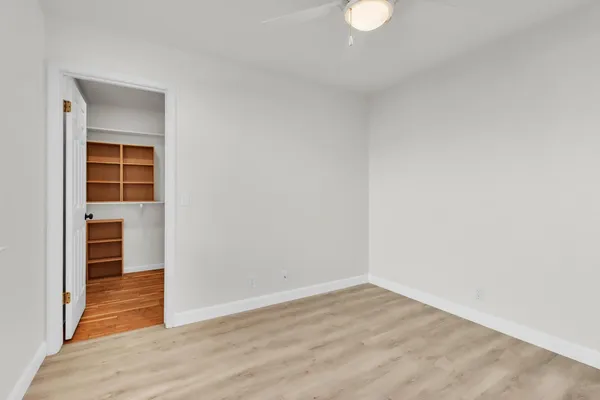 a view of empty room with wooden floor and cabinets