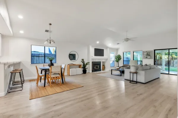 a living room with fireplace furniture and a large window