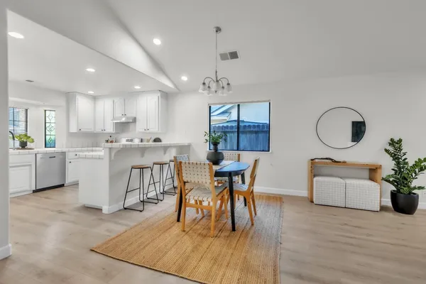 a dining room with wooden floor a glass table and chairs