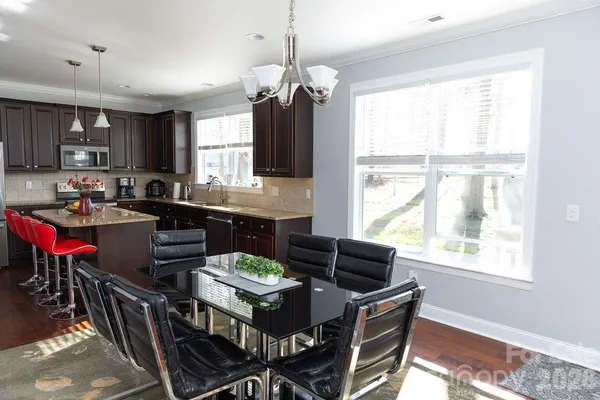 a kitchen with a dining table chairs and a refrigerator