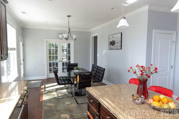 a dining room with furniture a chandelier and wooden floor