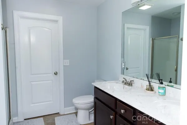 a bathroom with a granite countertop sink a toilet and a mirror