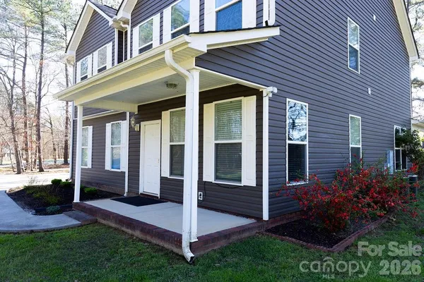 a view of a house with brick walls and a yard with plants