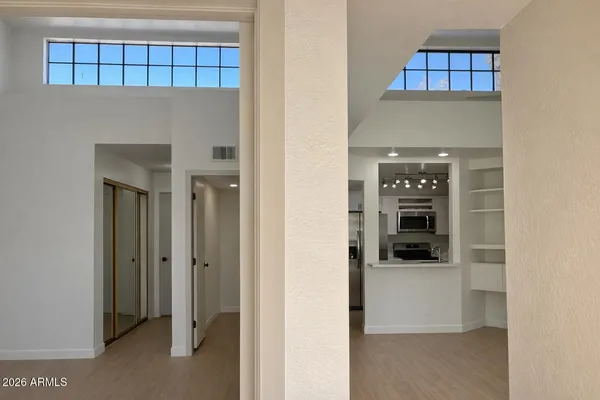a view of a hallway with wooden floor and entryway