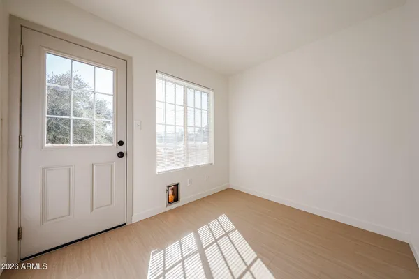 an empty room with wooden floor and windows