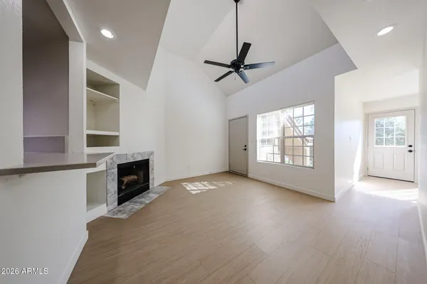 a view of empty room with wooden floor and fan