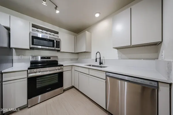 a kitchen with stainless steel appliances granite countertop a sink stove and microwave