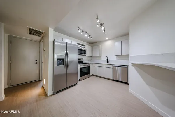 a large kitchen with cabinets and stainless steel appliances