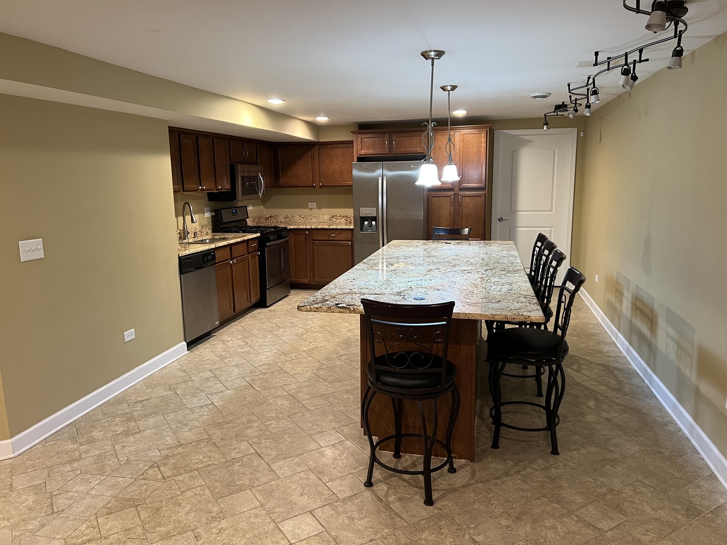 26112 Mapleview Drive Plainfield, IL 60585 - Photo 23 of 28 a kitchen with kitchen island a dining table chairs stainless steel appliances and cabinets
