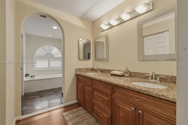 a bathroom with a granite countertop sink toilet and shower