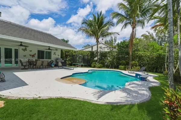 a swimming pool with outdoor seating and yard