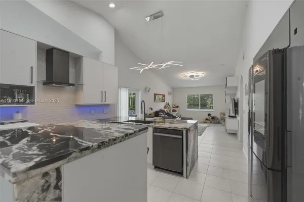 a kitchen with a dining table chairs cabinets and stainless steel appliances
