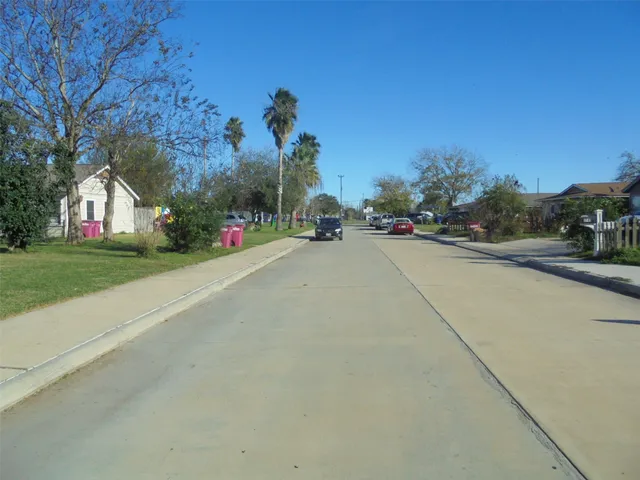 a view of a street with a building and trees in the background