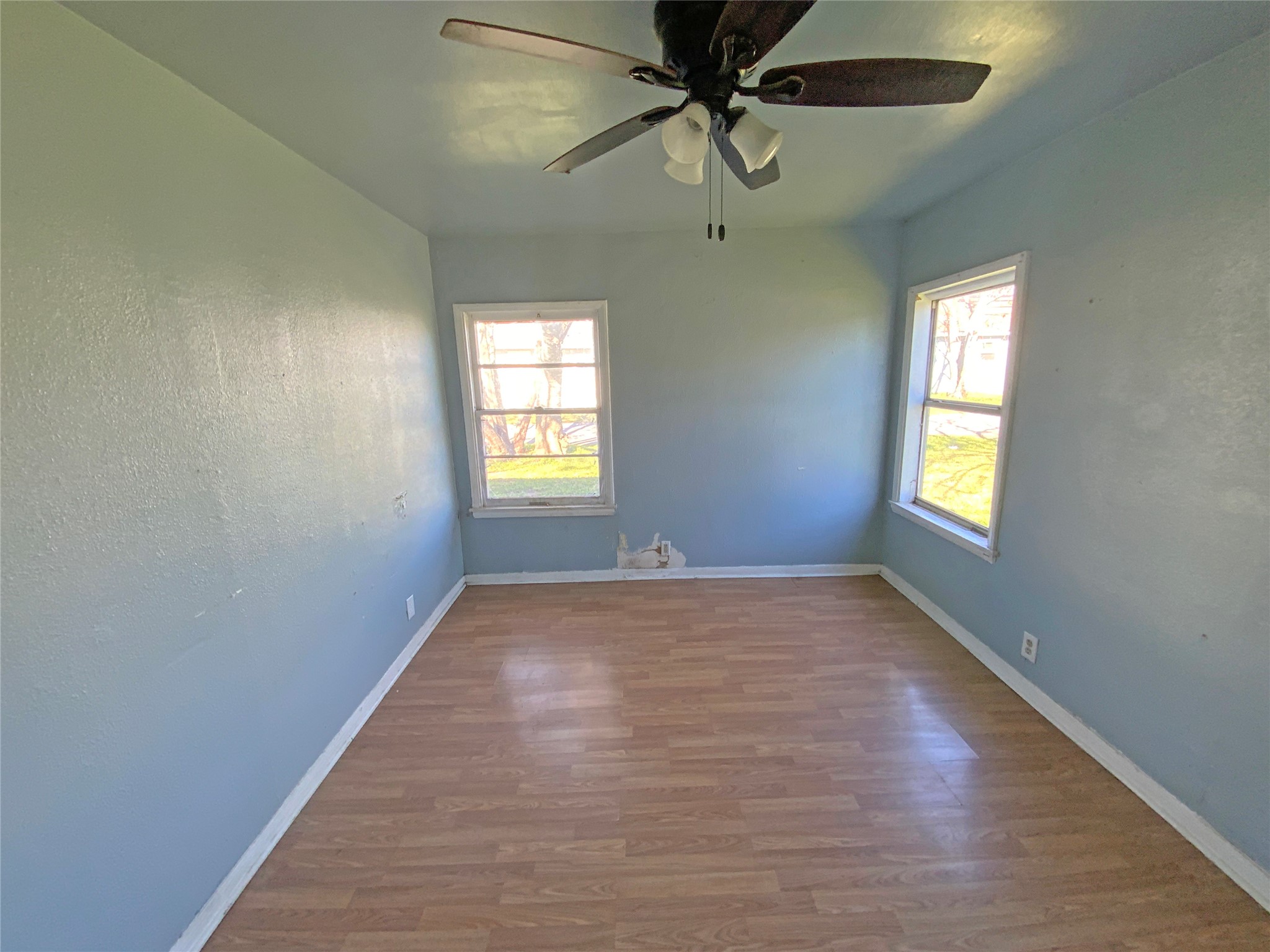 1736 Lynn Lane Freeport, TX 77541 - Photo 8 of 14 an empty room with windows and fan