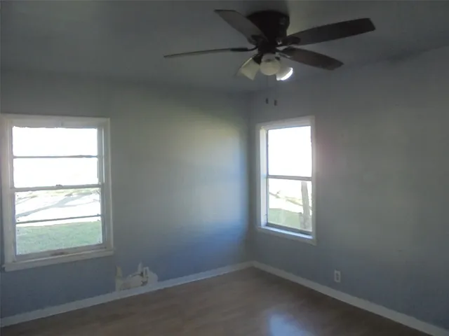 an empty room with a window and a fan