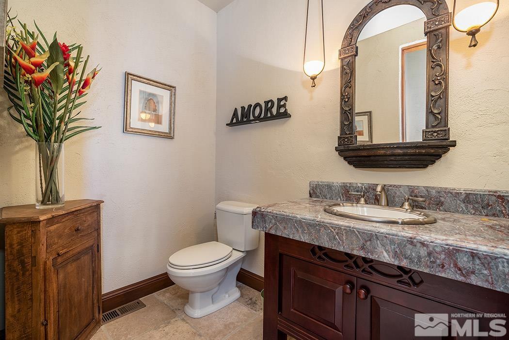 5835 Strasbourg Court Reno, NV 89511 - Photo 13 of 35 a bathroom with a granite countertop toilet a sink and a mirror