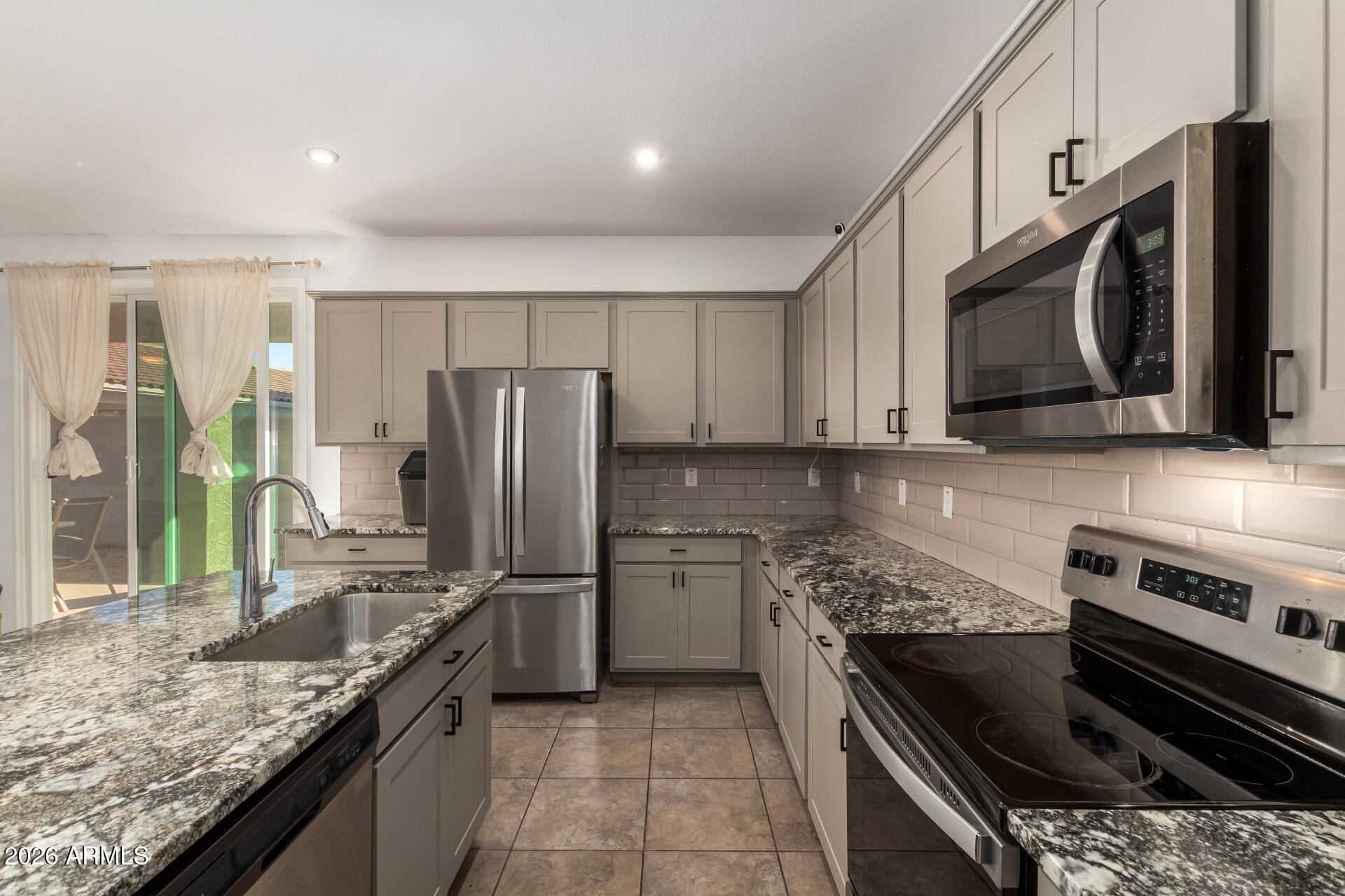 17449 West Patrick Lane Surprise, AZ 85387 - Photo 11 of 28 a kitchen with a sink stove and refrigerator
