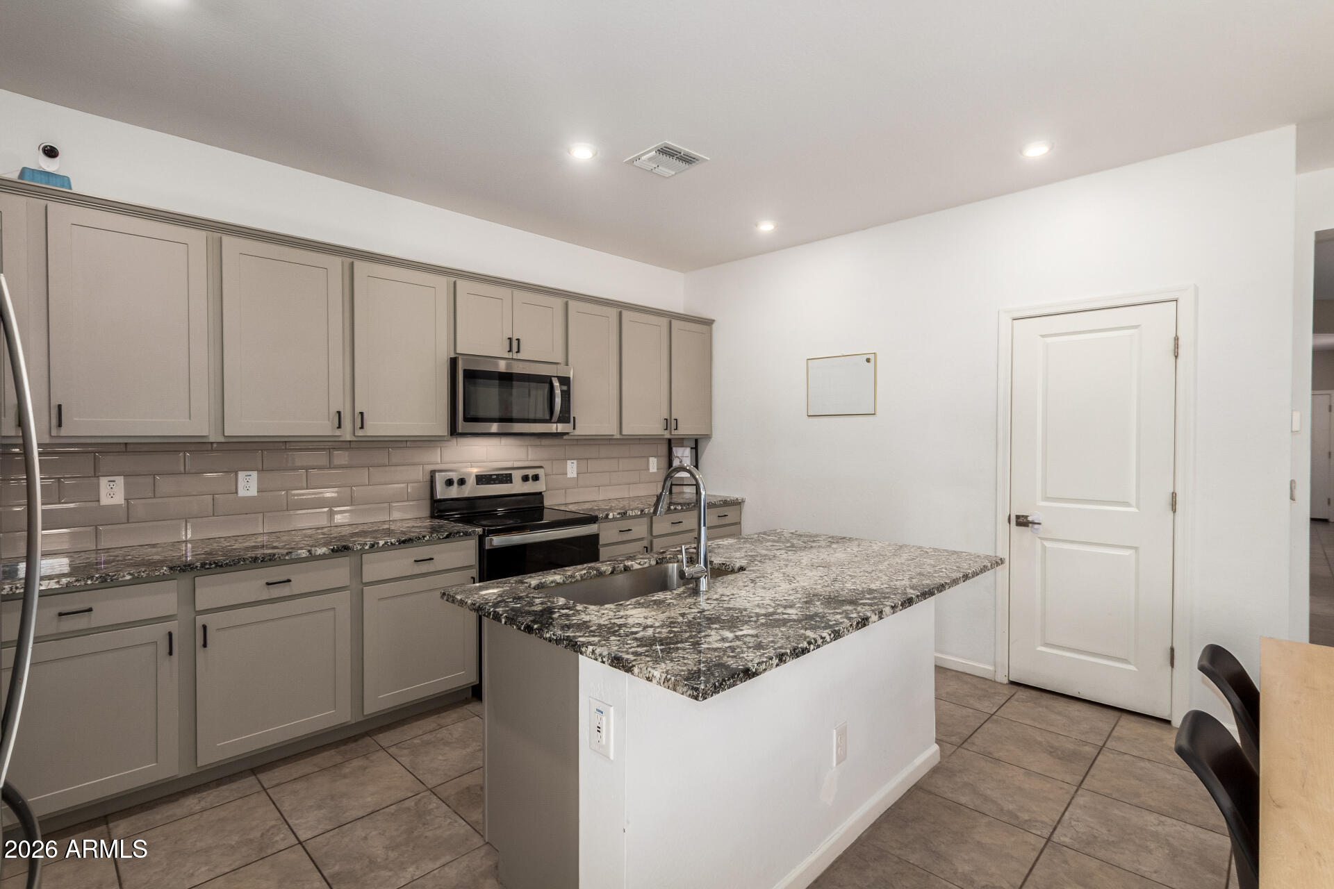 17449 West Patrick Lane Surprise, AZ 85387 - Photo 12 of 28 a kitchen with stainless steel appliances granite countertop a sink and dishwasher a stove top oven with wooden floor