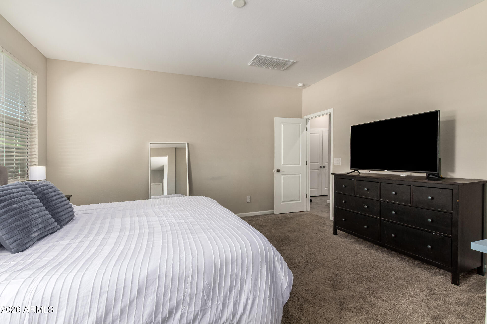 17449 West Patrick Lane Surprise, AZ 85387 - Photo 16 of 28 a bedroom with a bed and a flat screen tv