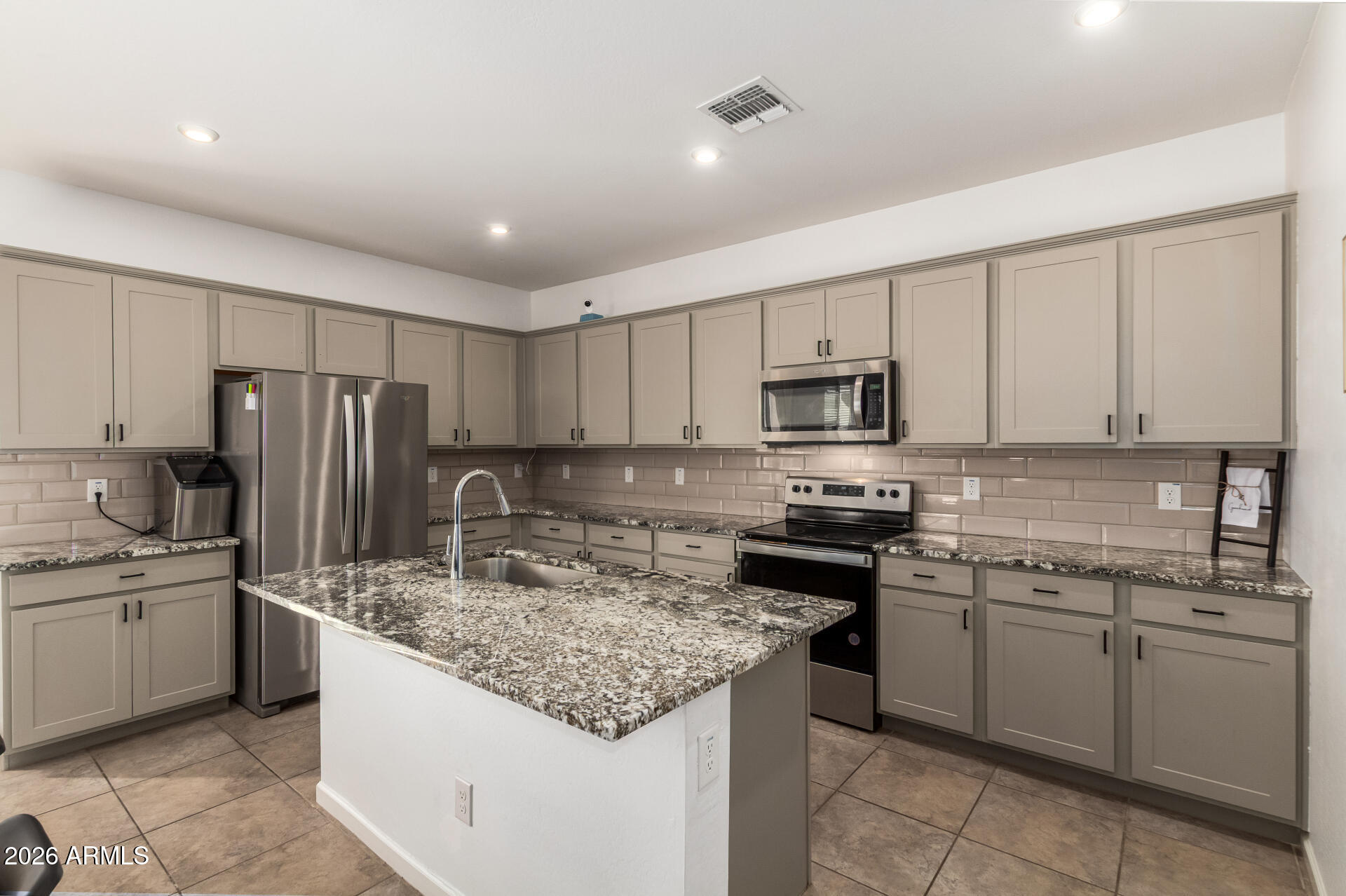 17449 West Patrick Lane Surprise, AZ 85387 - Photo 10 of 28 a kitchen with kitchen island granite countertop stainless steel appliances and white cabinets