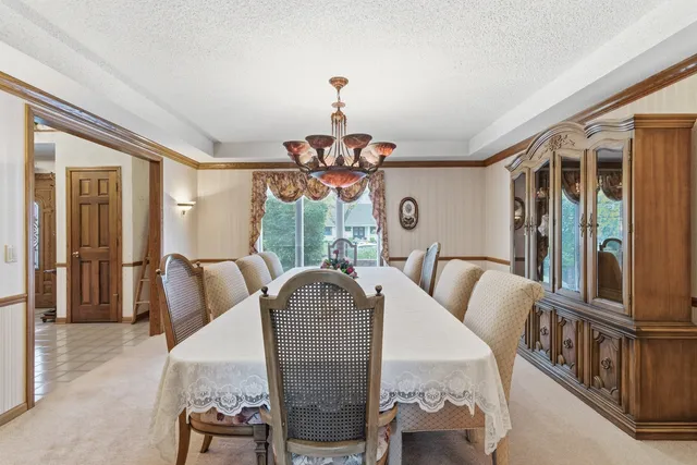 a view of a dining room with furniture a chandelier and wooden floor