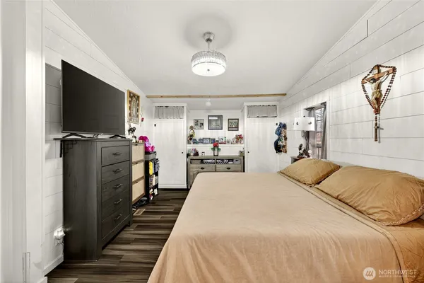 a bedroom with a bed and a flat tv screen on dresser