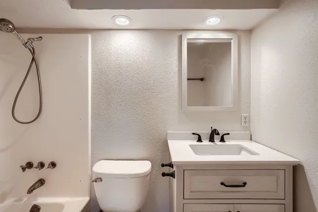 a bathroom with a sink a toilet and shower