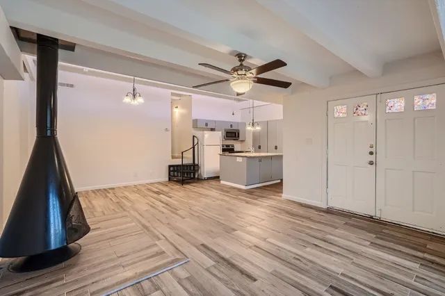 a view of a kitchen with wooden floor and a ceiling fan