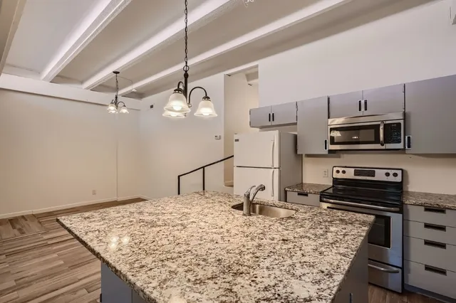 a kitchen with a stove and a wooden floor