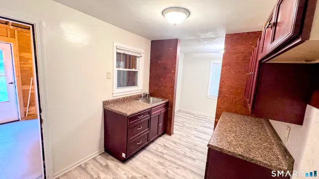 a view of empty room with wooden floor