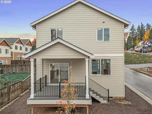 a view of a house with a small yard and wooden fence