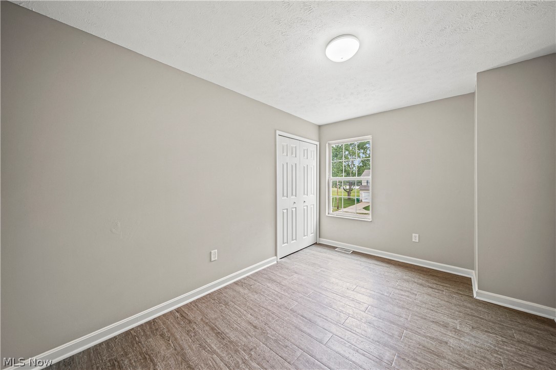 9576 Cloverleaf Road Windham, OH 44288 - Photo 19 of 29 Empty room with a textured ceiling and hardwood / wood-style flooring