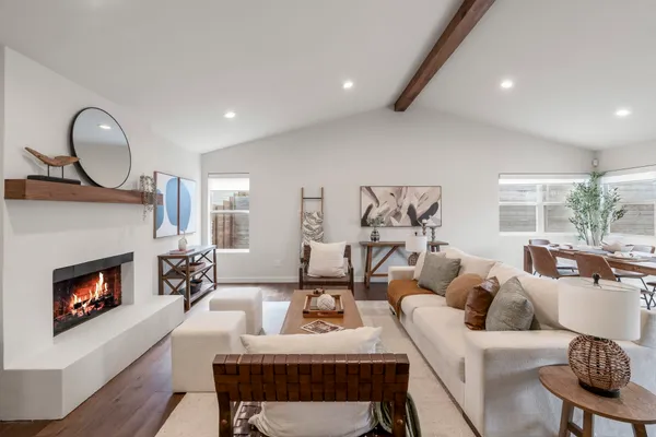 a living room with furniture a fireplace and a large window