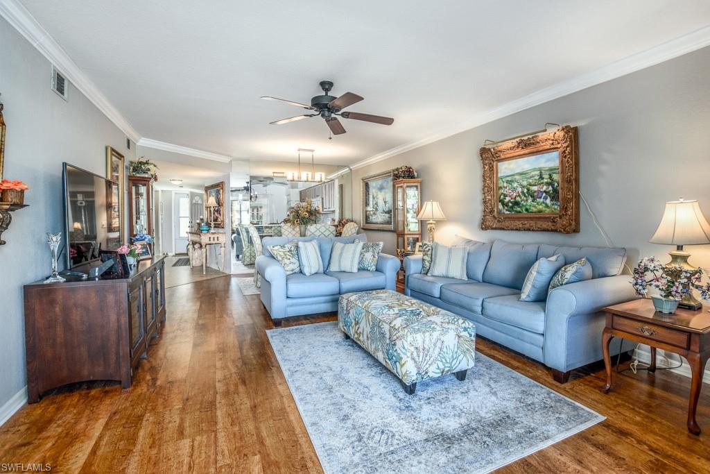 379 Gabriel Circle, Unit 2301 Naples, FL 34104 - Photo 11 of 33 a living room with furniture and a wooden floor