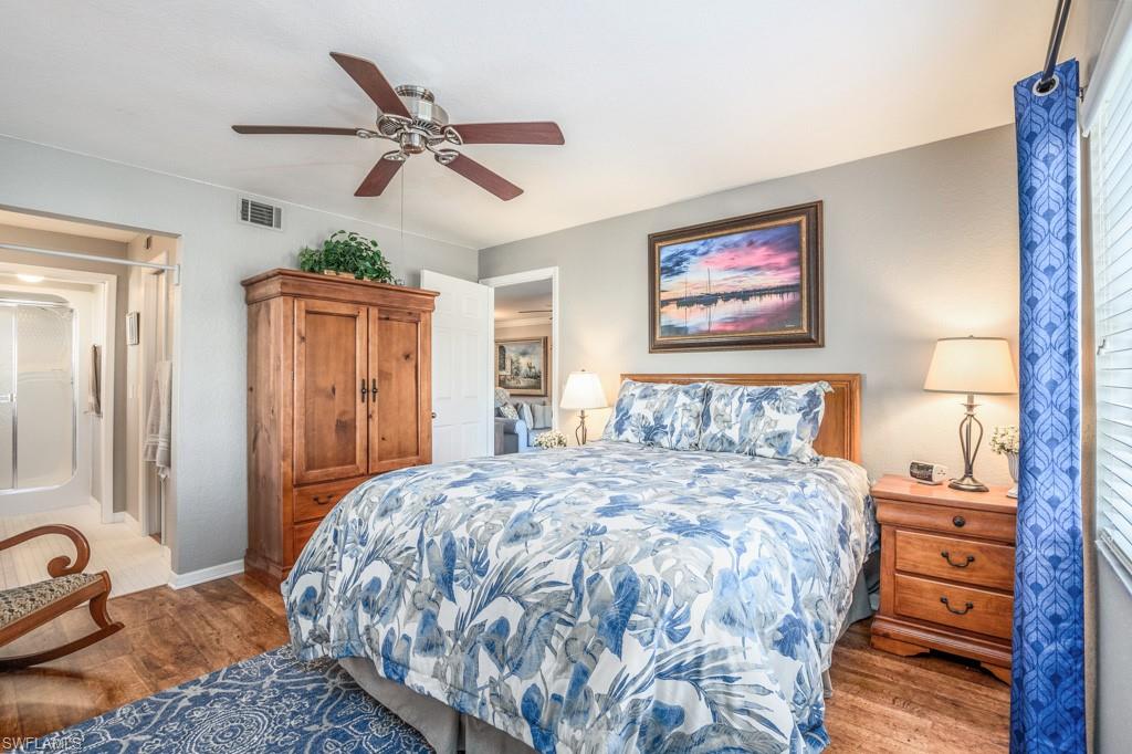 379 Gabriel Circle, Unit 2301 Naples, FL 34104 - Photo 15 of 33 a bedroom with a large bed and a chandelier