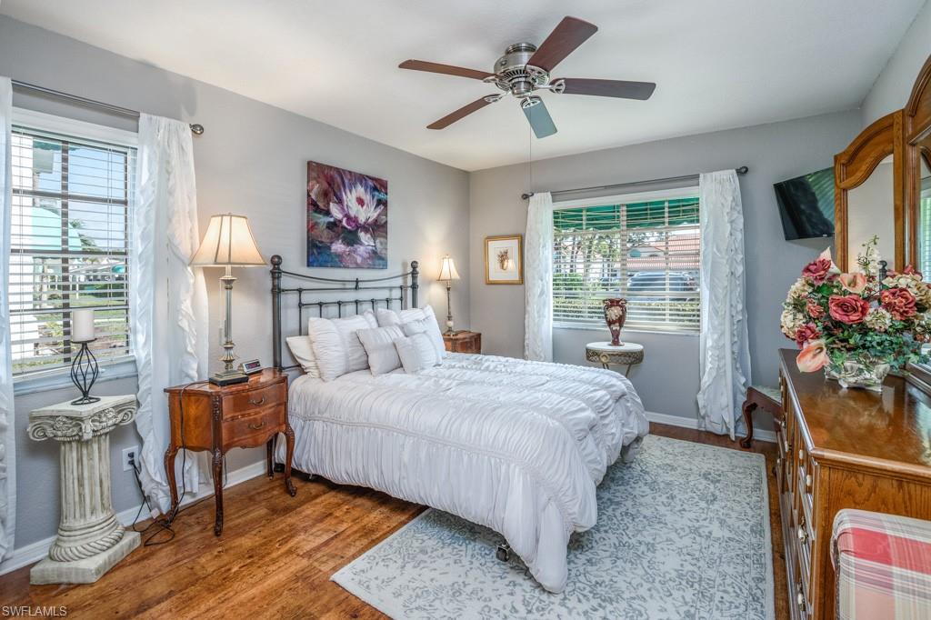 379 Gabriel Circle, Unit 2301 Naples, FL 34104 - Photo 19 of 33 a bedroom with a bed and a chandelier