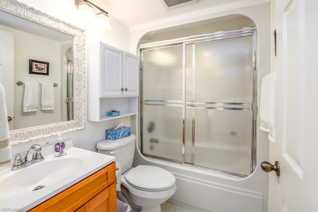 379 Gabriel Circle, Unit 2301 Naples, FL 34104 - Photo 22 of 33 a bathroom with a shower a sink a toilet and a mirror
