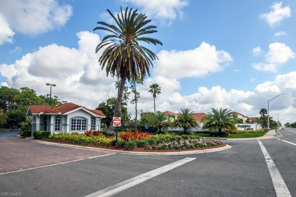 379 Gabriel Circle, Unit 2301 Naples, FL 34104 - Photo 32 of 33 a front view of a house with a garden and trees