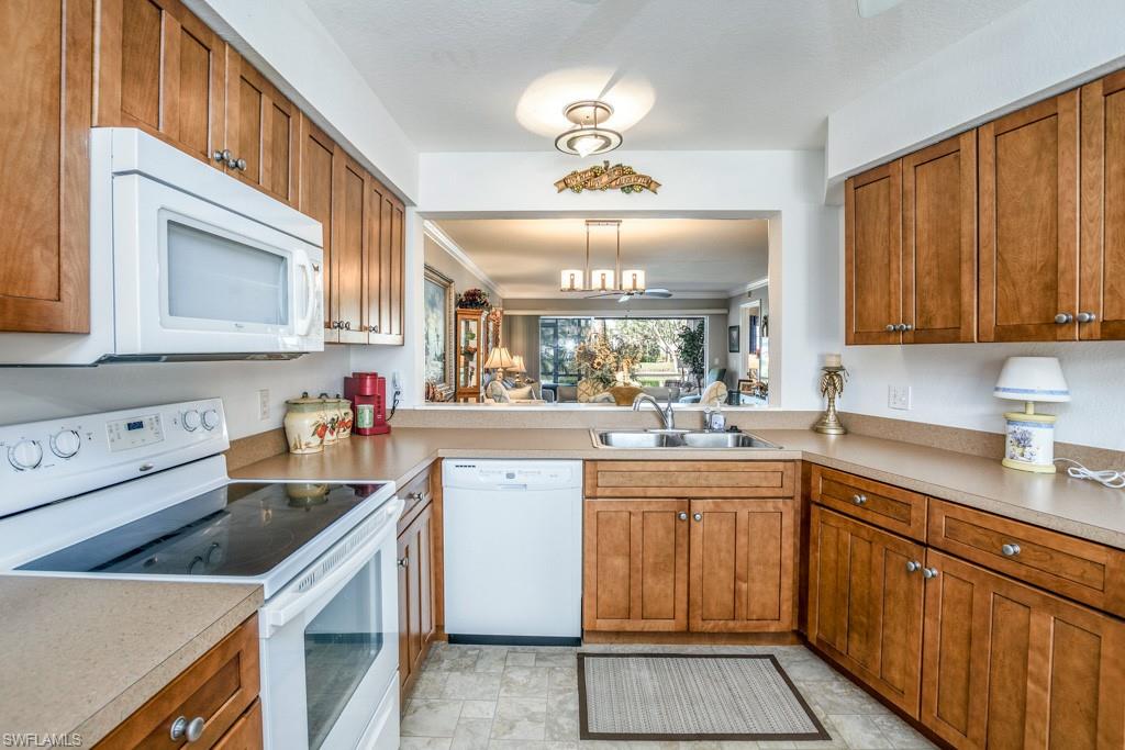379 Gabriel Circle, Unit 2301 Naples, FL 34104 - Photo 6 of 33 a kitchen with a sink dishwasher stove and cabinets