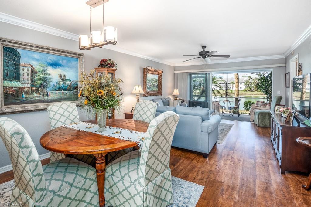 379 Gabriel Circle, Unit 2301 Naples, FL 34104 - Photo 9 of 33 a view of a dining room with furniture window and wooden floor