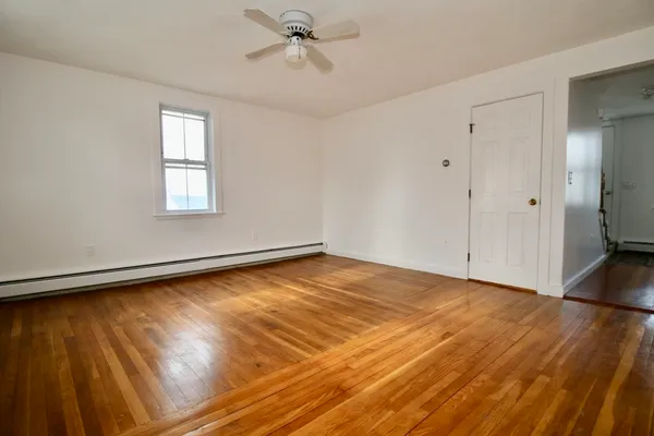 a view of a room with wooden floor and white walls