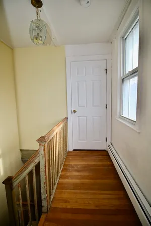 a view of a hallway with wooden floor and staircase