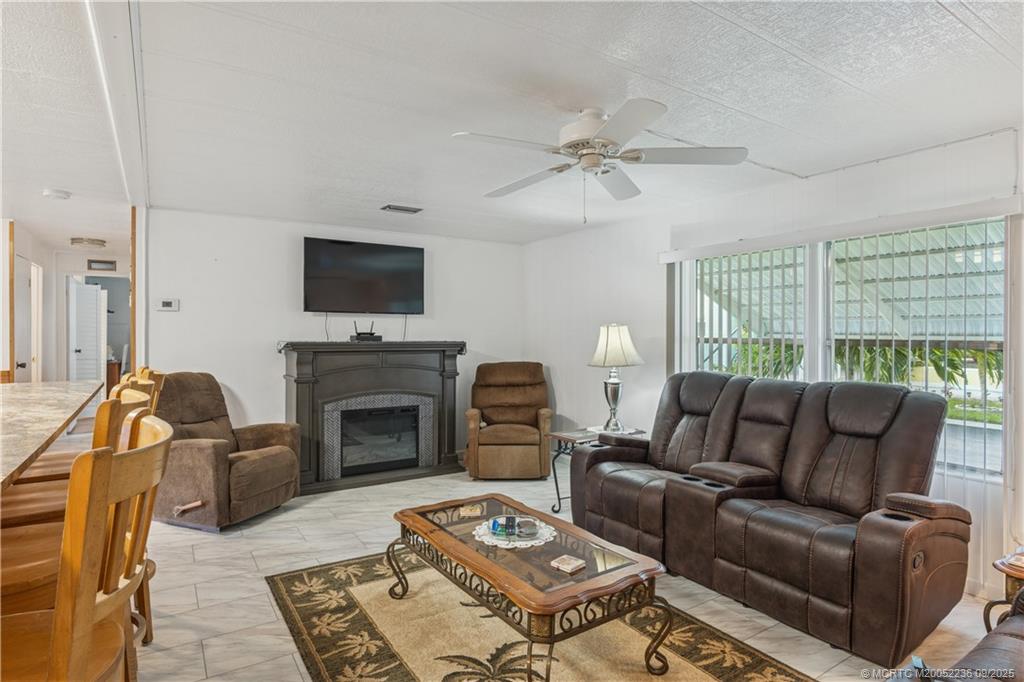 4800 Southeast Federal Highway, Unit 72 Stuart, FL 34997 - Photo 19 of 22 a living room with furniture a fireplace and a flat screen tv