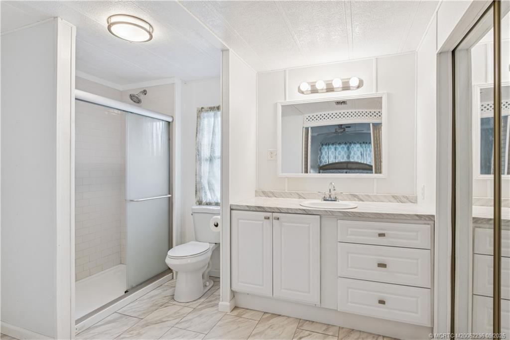 4800 Southeast Federal Highway, Unit 72 Stuart, FL 34997 - Photo 8 of 22 a bathroom with a granite countertop sink mirror and toilet