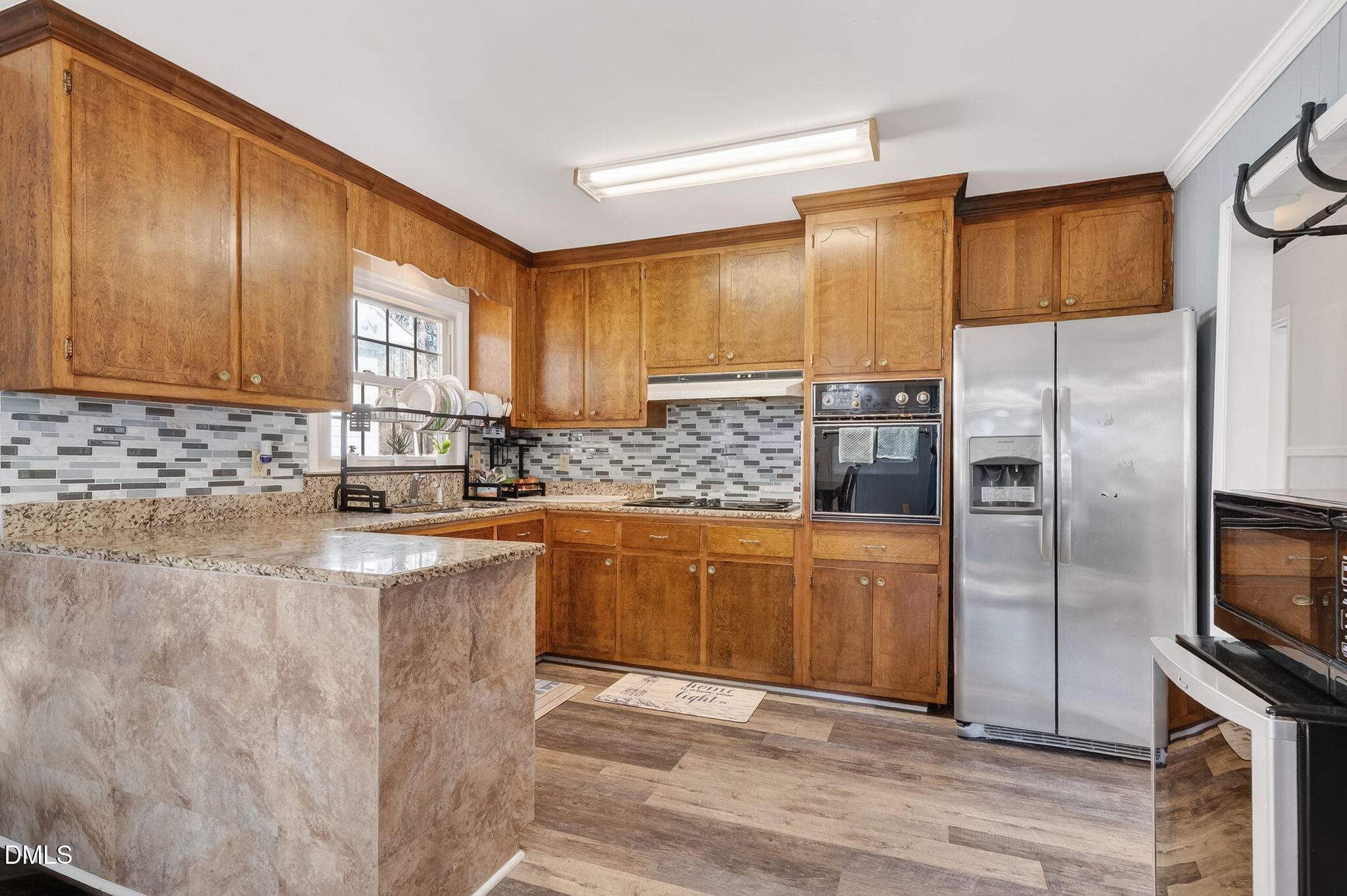 6201 Barrington Village Lane Raleigh, NC 27610 - Photo 12 of 25 a kitchen with stainless steel appliances granite countertop a refrigerator a stove and a sink with wooden cabinets