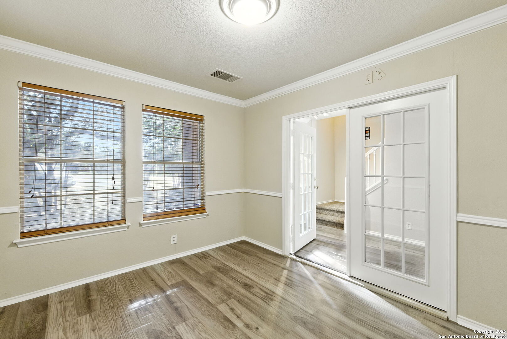 506 Leafy Ridge San Antonio, TX 78251 - Photo 6 of 48 a view of an empty room with wooden floor and a window