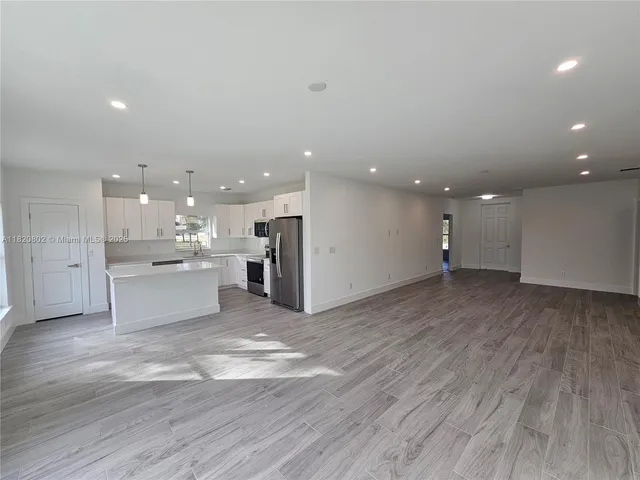 a view of large kitchen with a sink and a large window