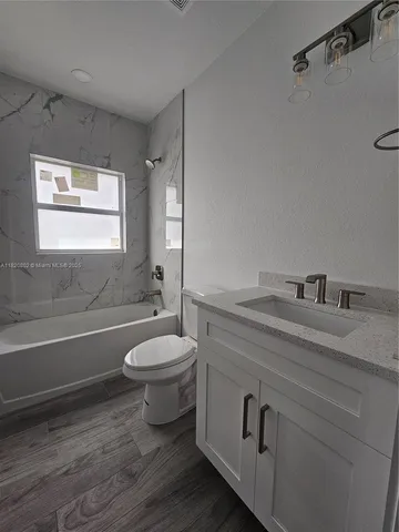 a bathroom with a granite countertop toilet sink and mirror